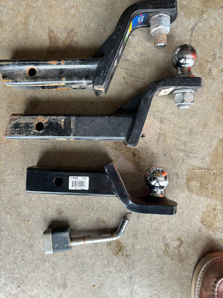 Towing essentials for your RV rental: multiple trailer hitch ball mounts & a hitch pin ready for use.