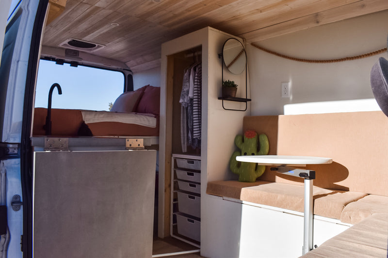 Inside a stylish RV rental: a comfortable bed, compact kitchen, ample storage, and versatile dining area. Ideal for travel. — photo 15