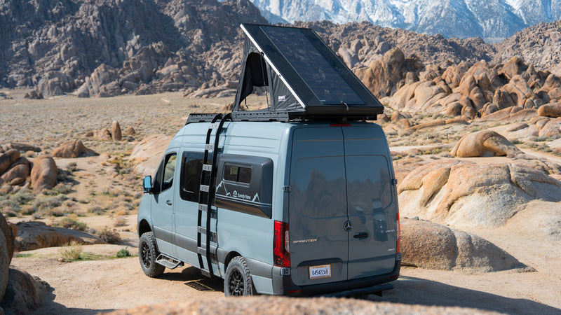 Gray Mercedes Sprinter camper van, perfect for rv rental, with rooftop tent/solar, in a rocky desert with snow-capped mountains. — photo 1