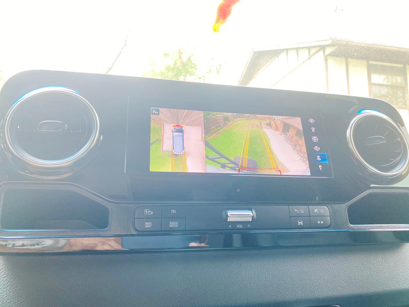 Inside an RV rental: Dashboard infotainment screen displays a 360° camera view, aiding parking by showing the vehicle and its surroundings.