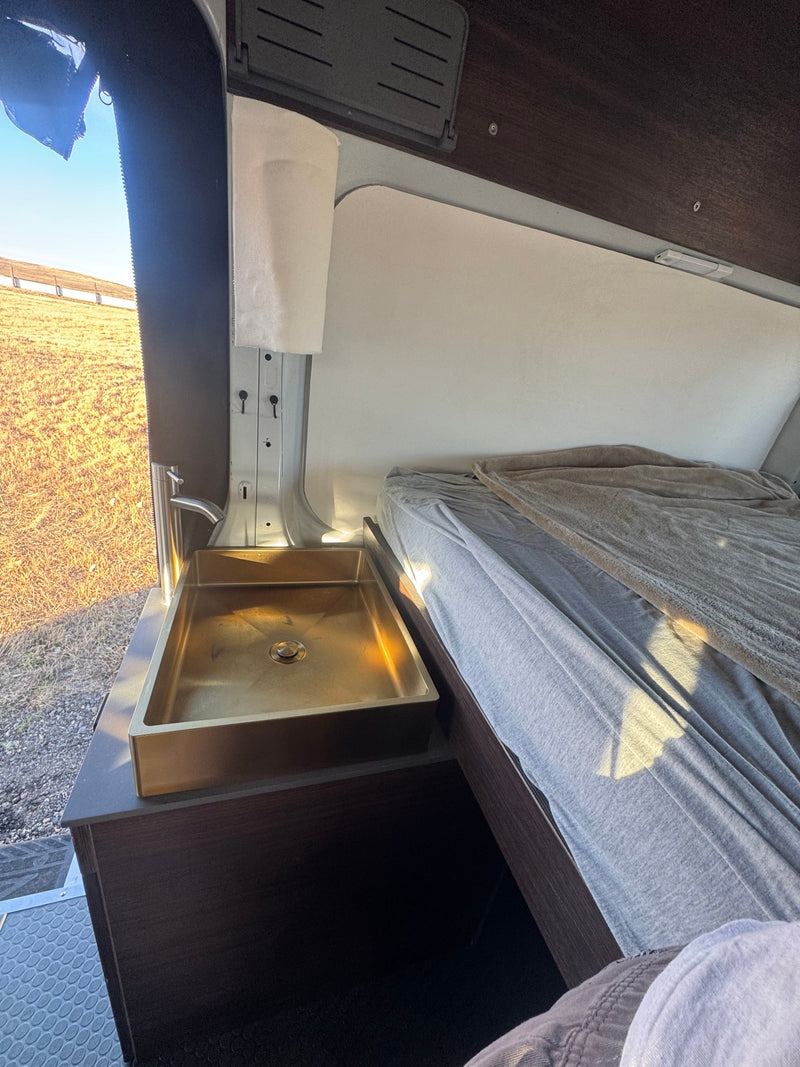  and tinted side windows.|A white Ford Transit **rv rental** camper van with a roof rack — photo 7