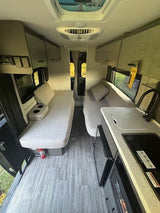 Experience this RV rental's modern interior. Features include a compact kitchen, convertible seating, and comfortable sleeping areas.