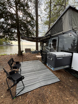 Waterfront RV rental setup with Dometic cooler, awning, and chairs. Perfect for camping by the lake or bay.