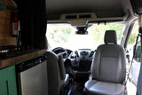 RV rental van interior: a kitchen area with stove, Frigidaire fridge, fire extinguisher, and the driver's cabin.