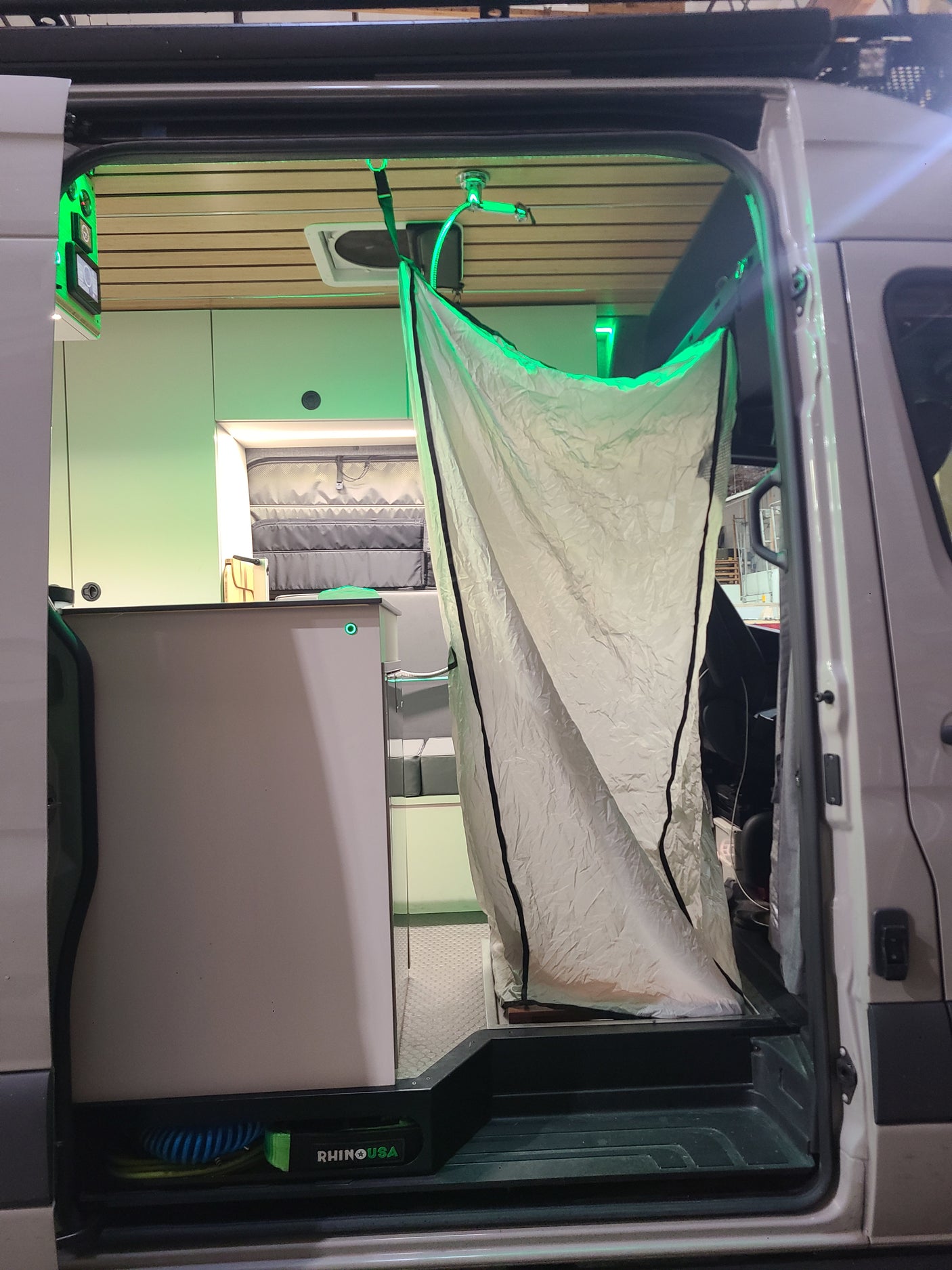 Step into this RV rental's innovative interior, highlighting a pop-up shower, vibrant green LEDs, and smart controls.