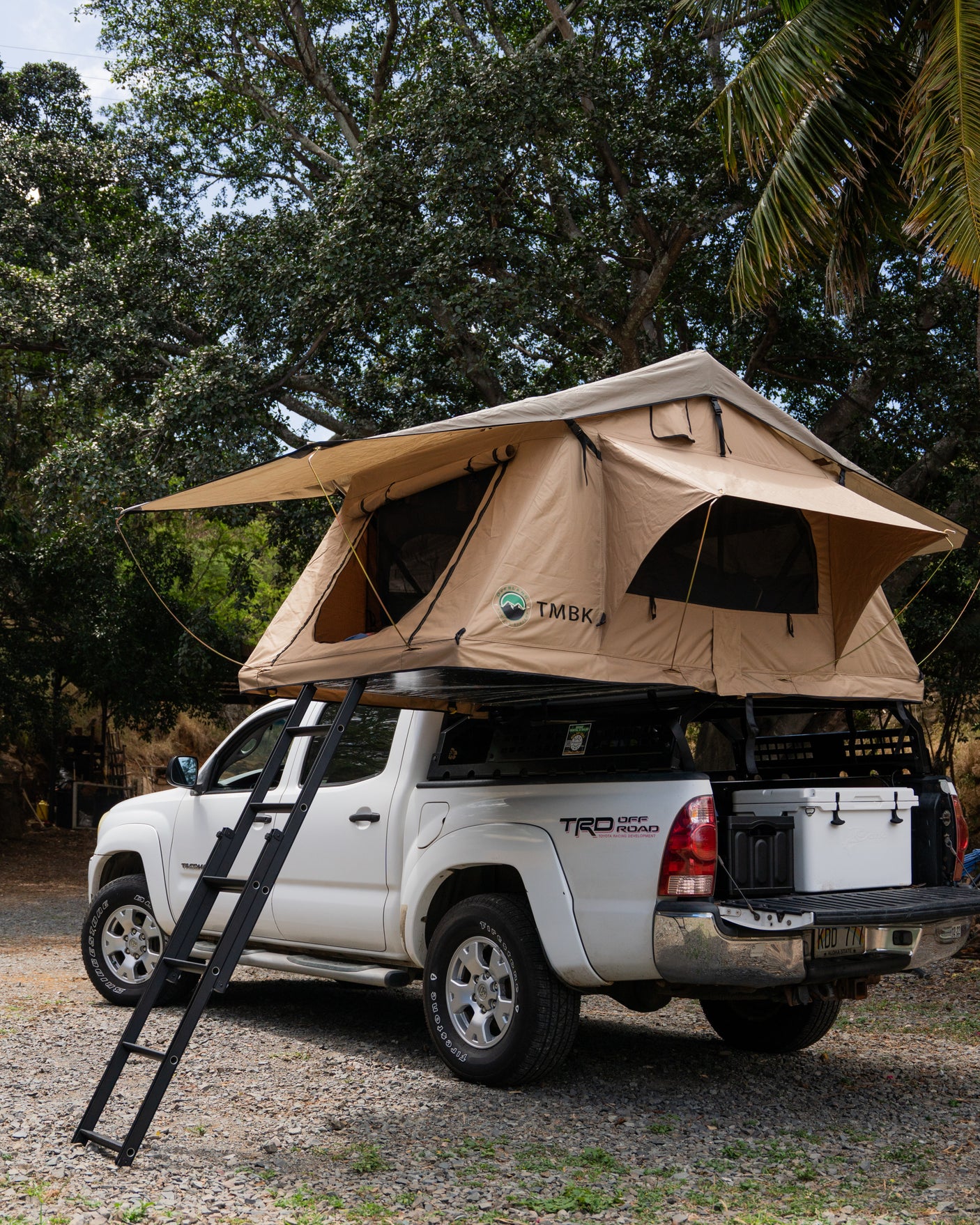 White Toyota Tacoma with a rooftop tent deployed. A unique RV rental option for overlanding and camping adventures.