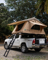 White Toyota Tacoma with a rooftop tent deployed. A unique RV rental option for overlanding and camping adventures.