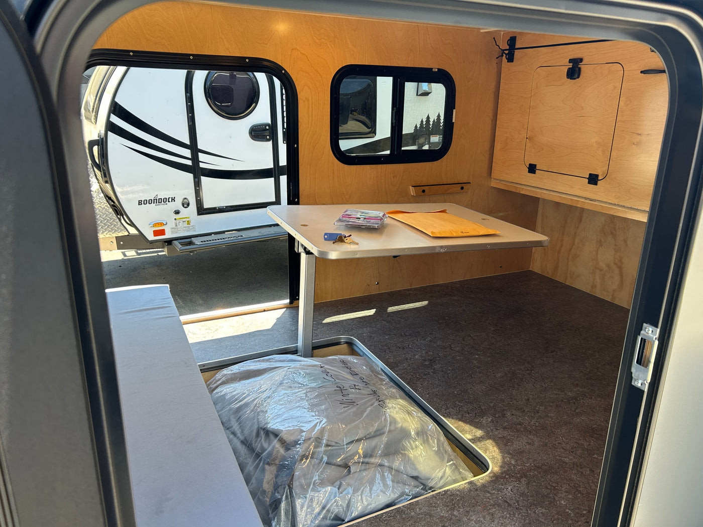 Explore this compact rv rental! Interior features wood paneling, convertible dinette, and ample storage for your journey. — photo 5