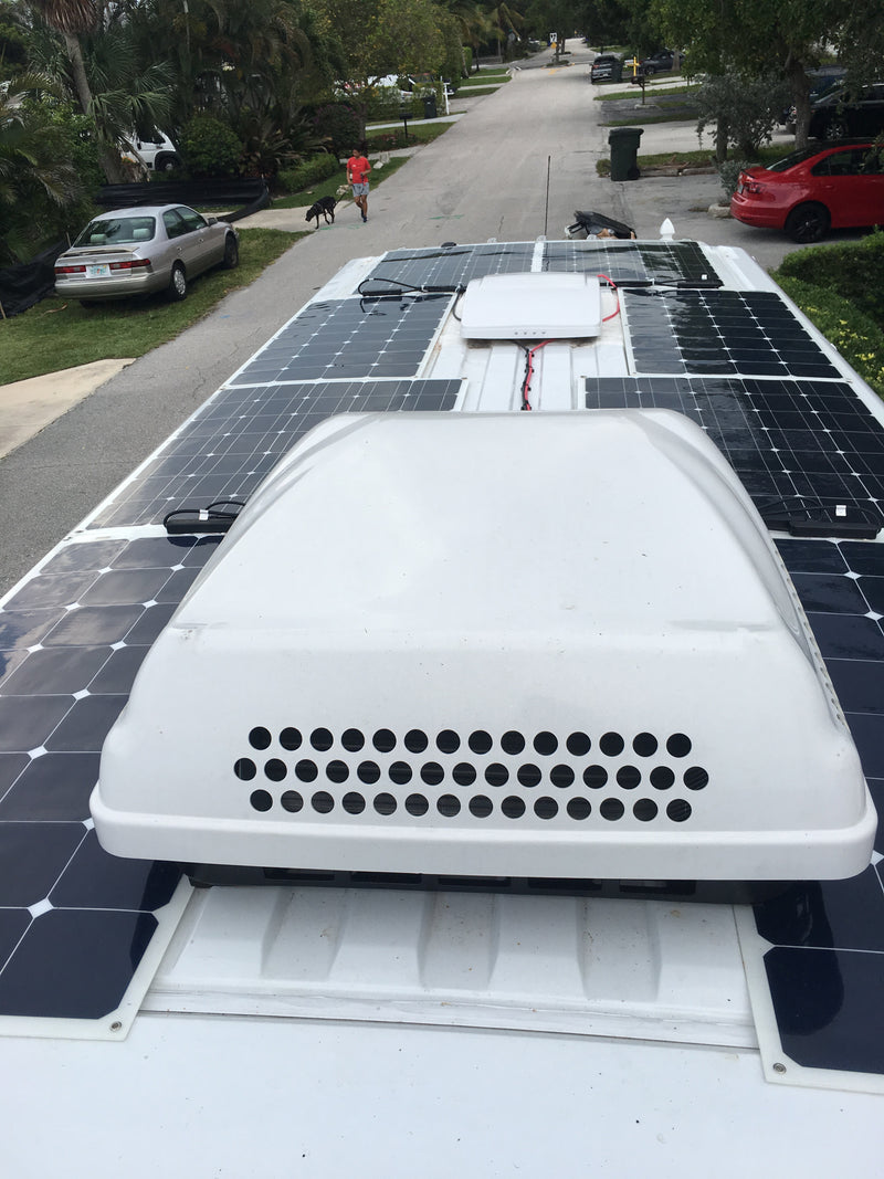 Multiple solar panels and an AC unit top this RV rental, providing off-grid power for adventures. — photo 6