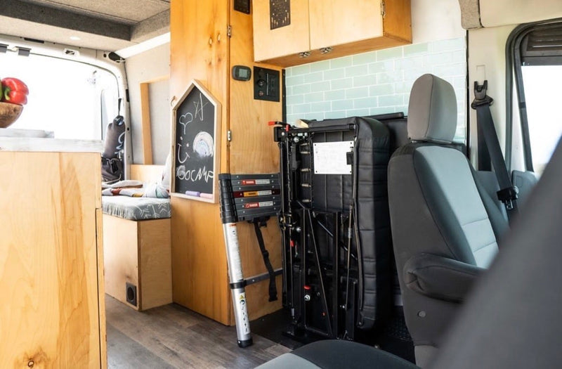 Inside an RV rental van: custom wooden interior, chalkboard, foldable seat, and telescoping ladder for versatile adventures. — photo 6