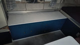 RV rental: Renovated interior with vibrant blue cabinets, white countertop, and cozy sleeping area.