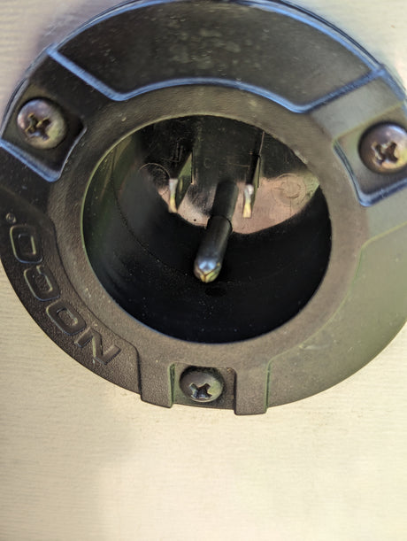 NOCO RV rental charging port showing a male electrical inlet with three pins.