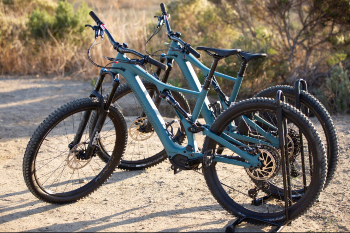 Two teal e-mountain bikes, ready for an RV rental adventure. Perfect for outdoor exploration and trail riding.