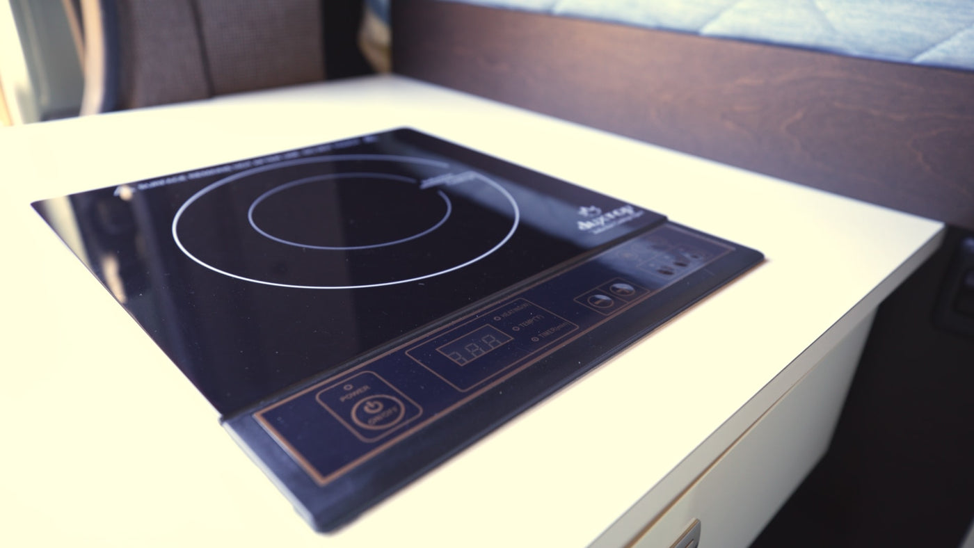 An induction cooktop with a digital display and touch controls sits on a light counter in an RV rental, ideal for compact cooking. — photo 12