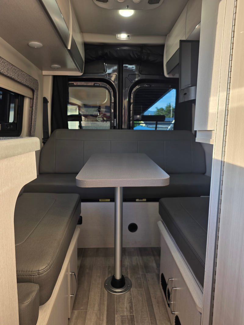 Interior of an RV rental: a bright dinette features a U-shaped bench, table, and overhead cabinets. Ready for travel. — photo 5