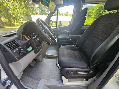 RV rental van interior. View of driver's area & passenger seat, steering wheel, dash, & 'DIESEL FUEL ONLY' sticker.