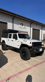 White Willys Jeep Gladiator with a rooftop tent, customized for overlanding adventures. Perfect for your next RV rental.