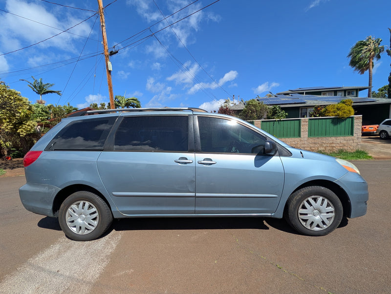 Light blue minivan on sunny street. Great for road trips & exploring destinations — photo 1