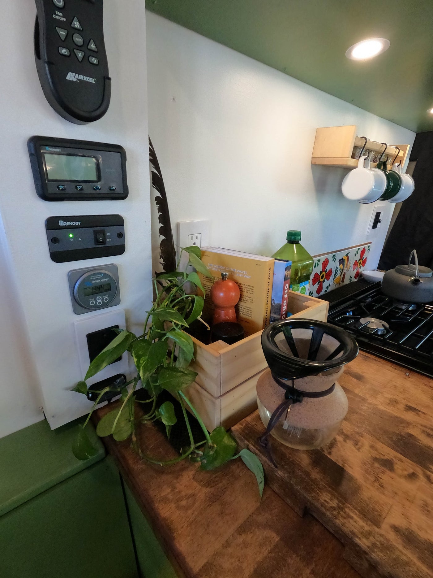 Inside an RV rental: a compact kitchen with power monitors, stove, and coffee gear, ready for off-grid adventures. — photo 18