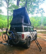 Adventure-ready Bronco with rooftop tent, ladder & bike rack. Enjoy off-grid camping like an RV rental!
