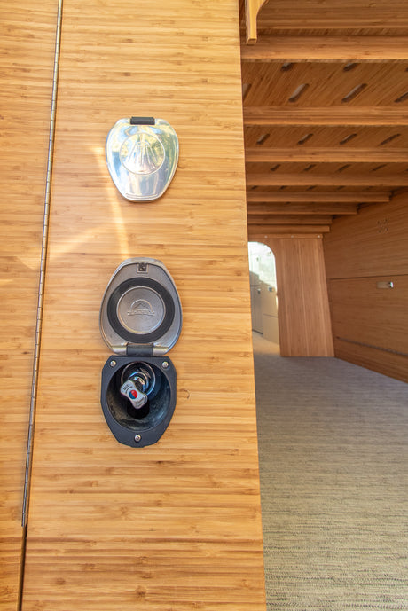 RV rental exterior shower connections on bamboo paneling, with an open Scandvik hot/cold mixer.