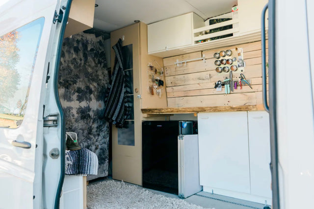  two people and two dogs enjoying the outdoor setting.|This RV rental's inviting interior features a well-equipped compact kitchen