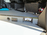 RV rental interior with grey textured floor, electrical outlet, water hookup, and fire extinguisher for safety.