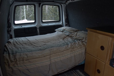 Cozy RV rental campervan interior: a comfy bed with snowy views, perfect for a road trip or camping. — photo 10