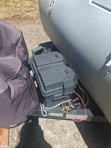 The front hitch of an RV rental shows a "Snap-Top" battery box providing power, along with essential electrical connections.