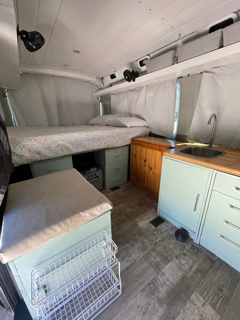 Cozy RV rental interior with bed, kitchen, and smart storage, perfect for a comfortable journey. — photo 6