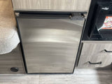RV rental kitchen showing a stainless steel Nova Kool refrigerator and High Pointe oven/microwave. Functional space.