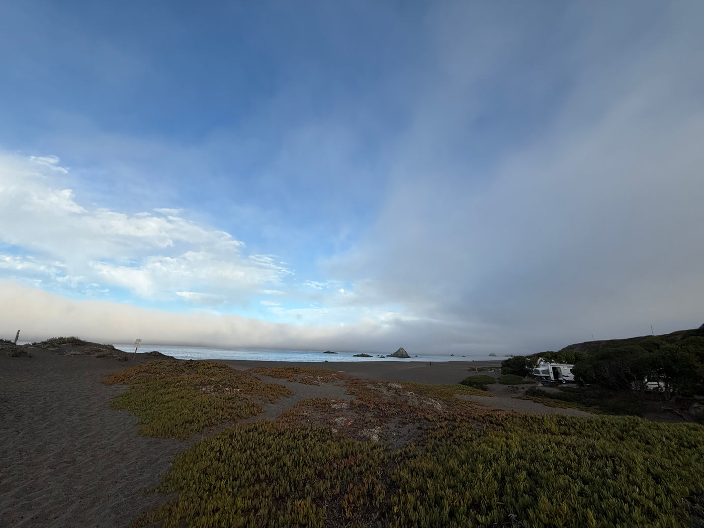 RV rental parked near a misty beach with dense fog rolling in from the ocean. — photo 17