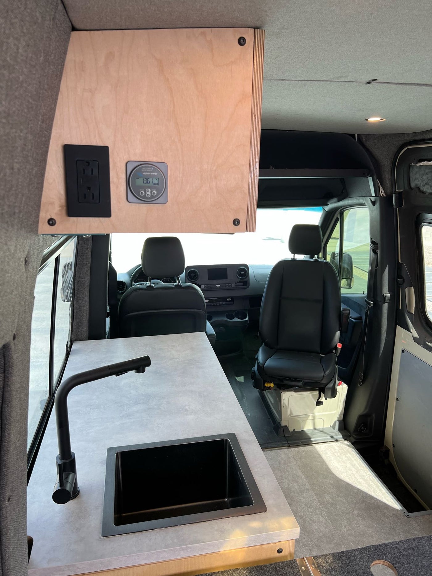  this RV rental shows a spacious driver's cabin with black seats and dashboard.|Spacious RV rental driver's area with comfortable seat — photo 18