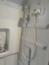 This RV rental features a clean, compact white shower with a handheld showerhead and shampoo.