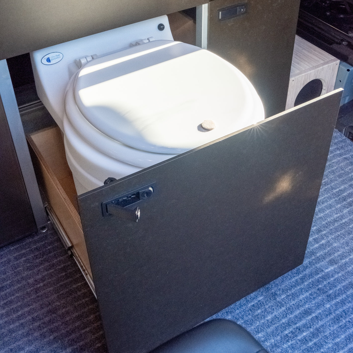 RV rental convenience: A pull-out dry flush toilet in a compact camper van for smart space use.