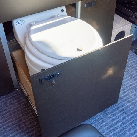 RV rental convenience: A pull-out dry flush toilet in a compact camper van for smart space use.