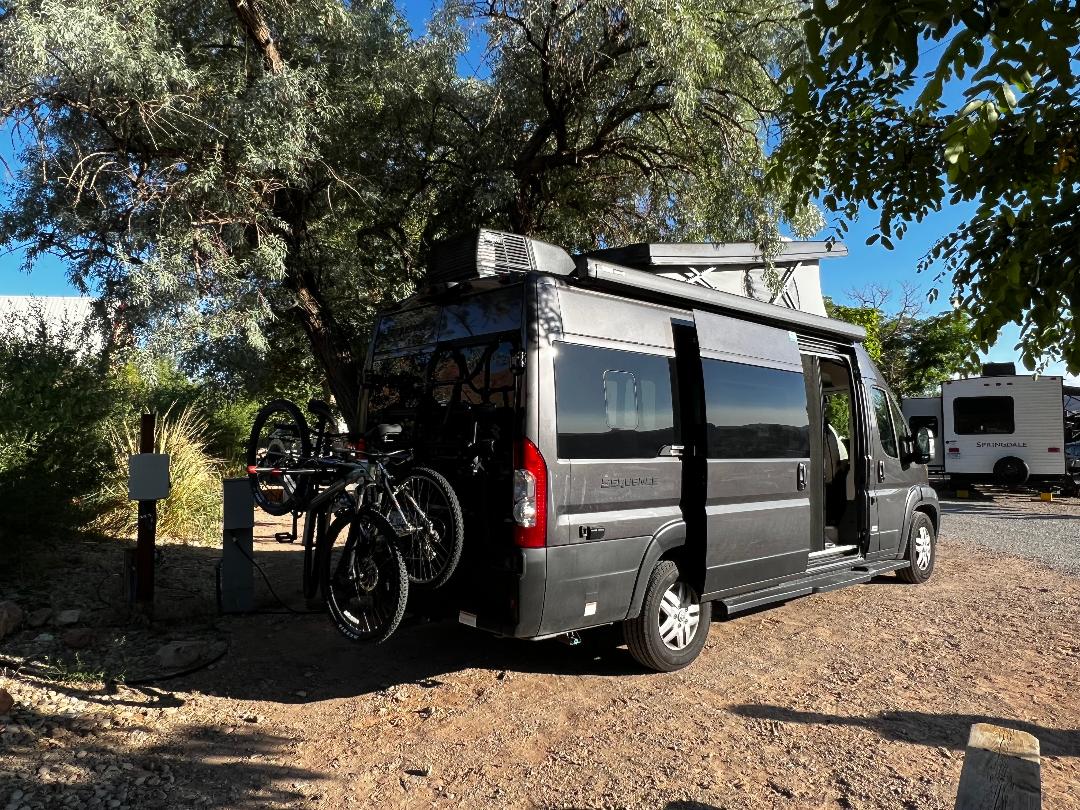 and a side awning.|Side view of a dark gray pop-top camper van for rv rental — photo 5