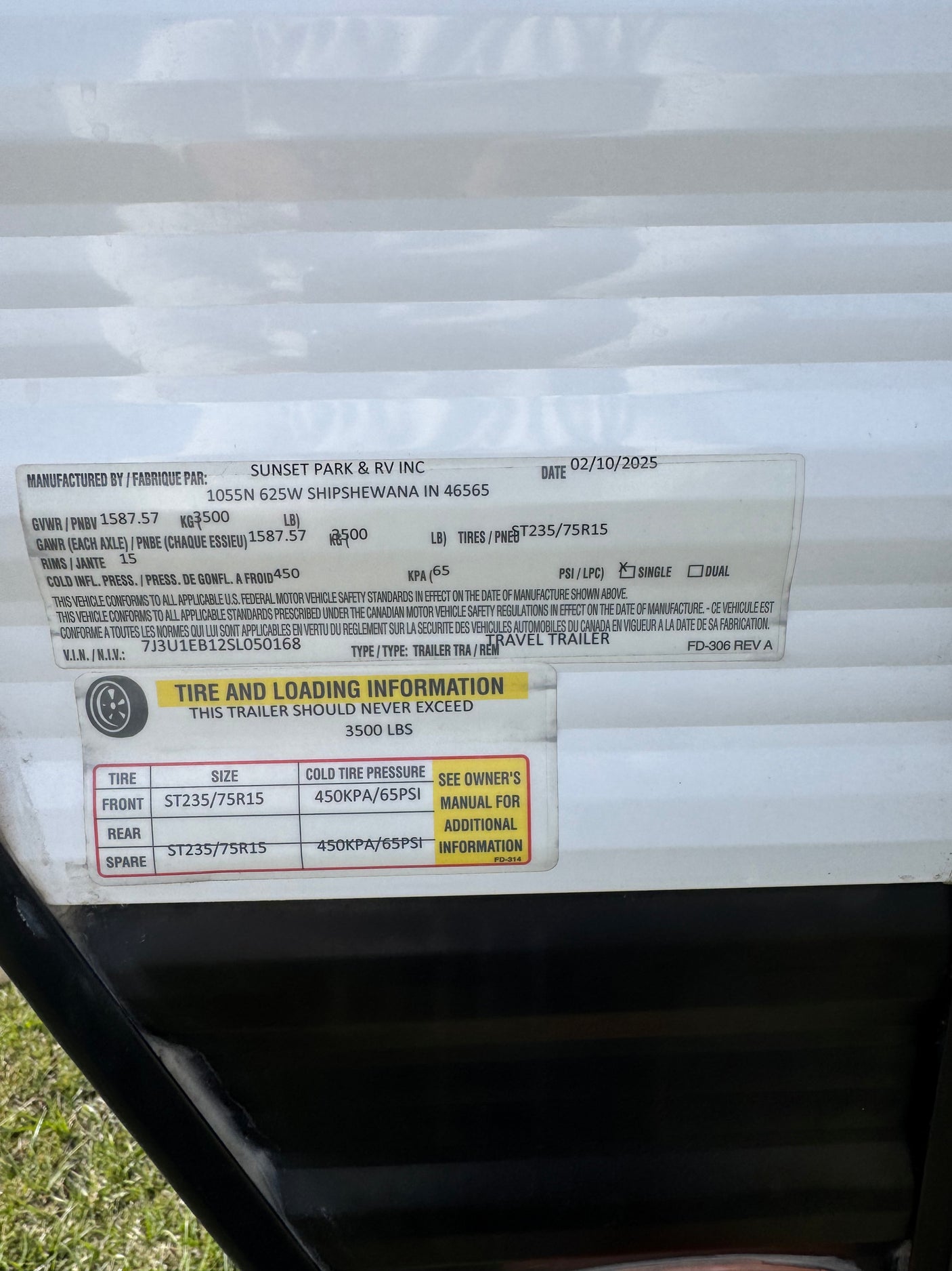 RV rental travel trailer specs: safety label with VIN, GVWR, tire size (ST235/75R15), and 65 PSI cold tire pressure details.
