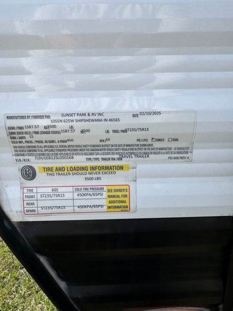 RV rental travel trailer specs: safety label with VIN, GVWR, tire size (ST235/75R15), and 65 PSI cold tire pressure details.