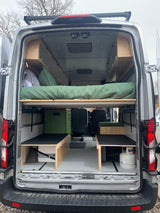 Inside a custom RV rental van, featuring a cozy sleeping area, ample storage, and functional living space for adventures.