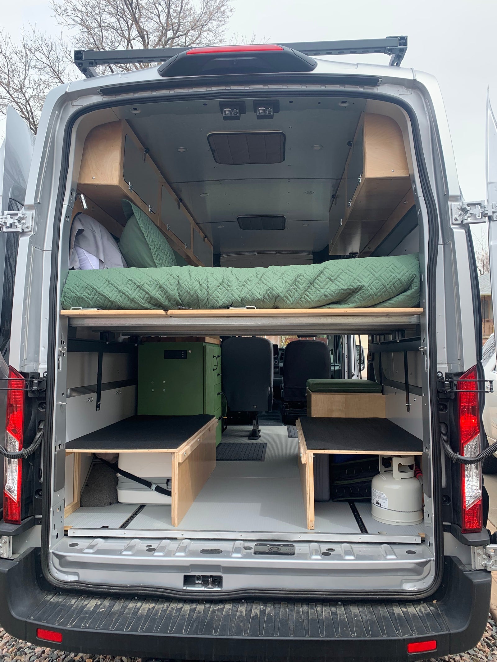Inside a custom RV rental van, featuring a cozy sleeping area, ample storage, and functional living space for adventures.