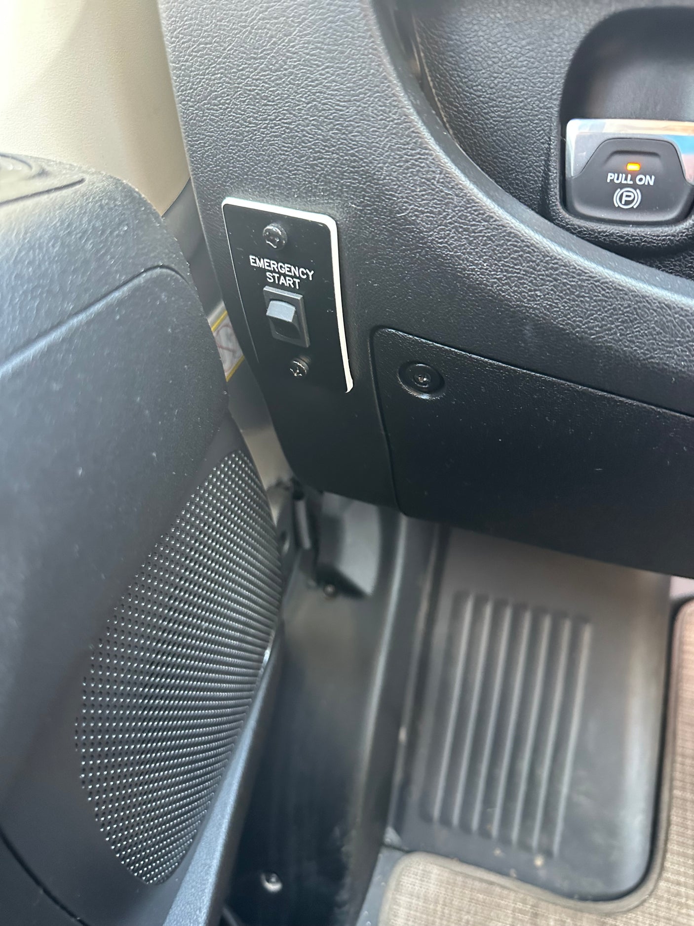RV rental interior: an 'Emergency Start' toggle switch and electronic parking brake 'Pull On (P)' button with a speaker grill.