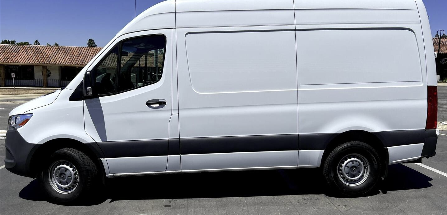Side view of a clean, white cargo van, ideal for an RV rental conversion or commercial transport.