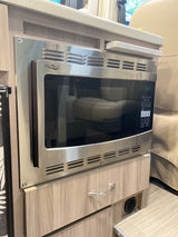 Built-in stainless steel microwave oven, ready for meals in this rv rental. Features digital display and control panel within a compact kitchenette.