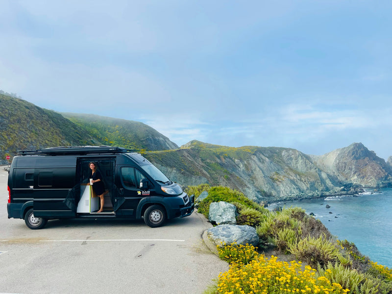  showcasing a functional mobile office in a comfortable camper van setup.|Inside a modern RV rental: light wood walls — photo 14