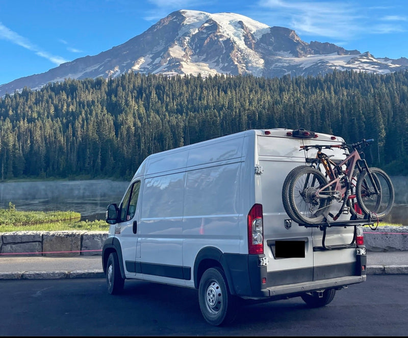 White RV rental van with mountain bikes — photo 1