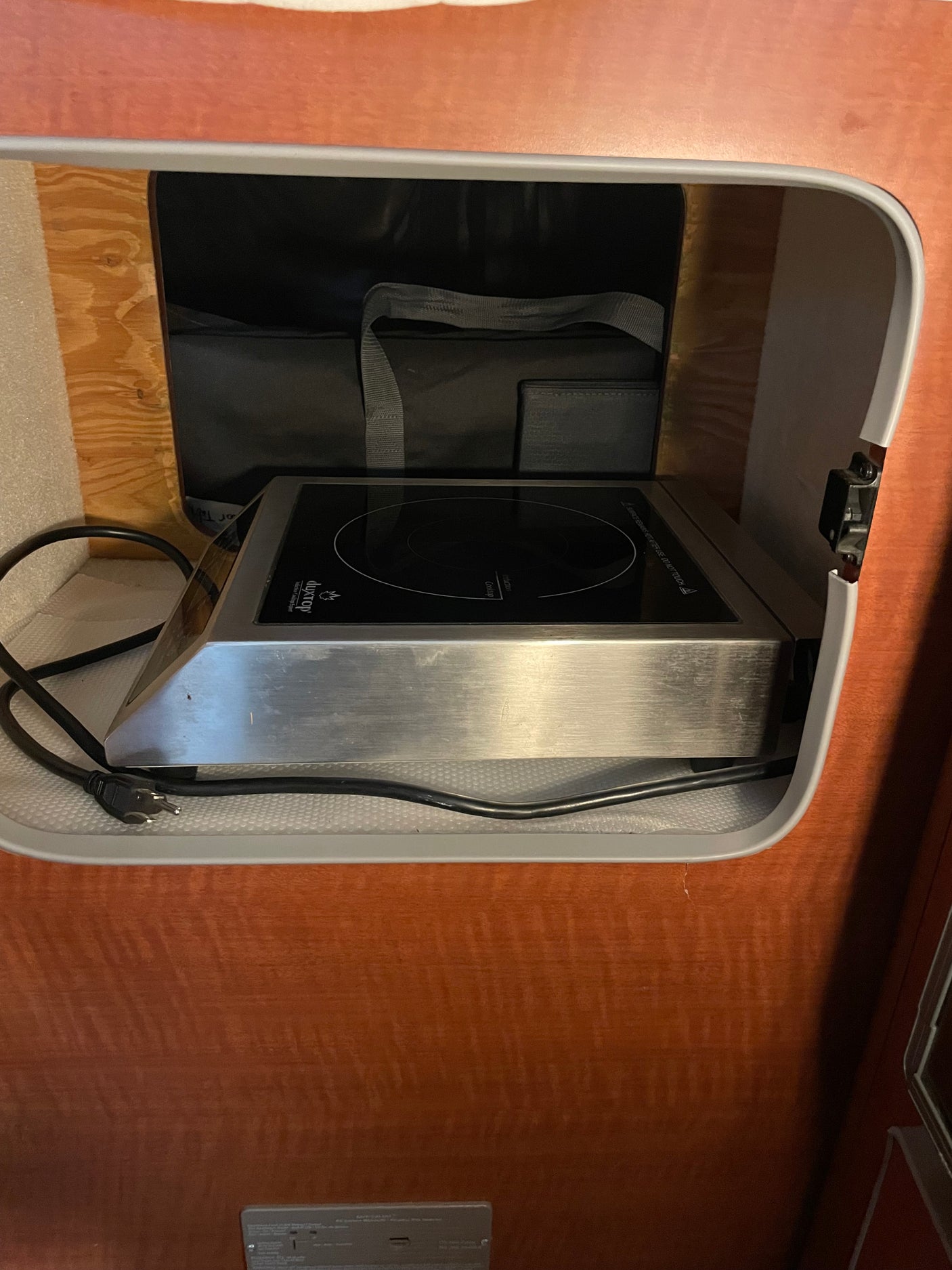 This RV rental features a compact duxtop induction cooktop, smartly stored in a cabinet for easy access.