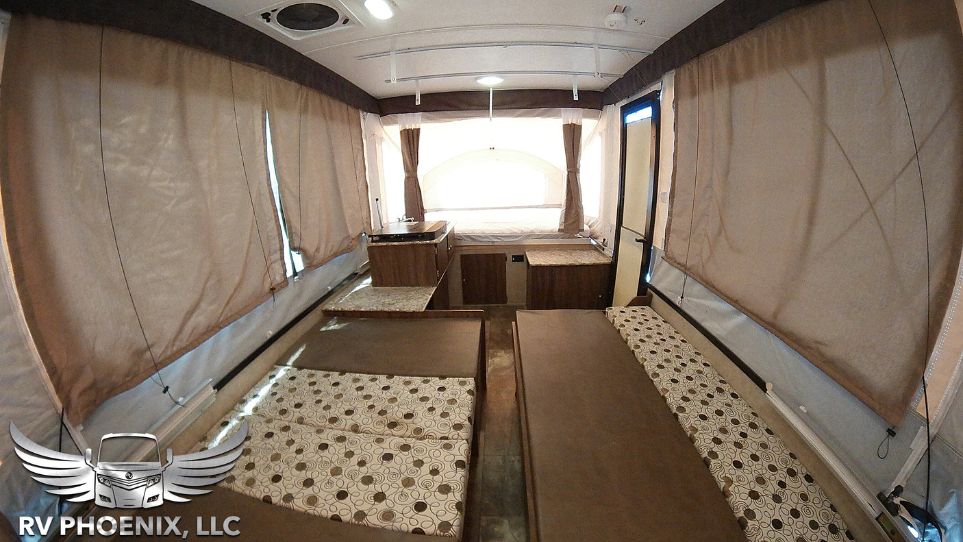 RV rental pop-up camper interior: featuring convertible beds, a small kitchen, and open living space for adventure.