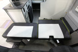 Inside this RV rental camper van: compact kitchen with sink/fridge, alongside adaptable black/white seating.