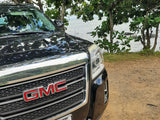 A black GMC SUV parked by calm water and trees. Perfect for exploring your rv rental route.